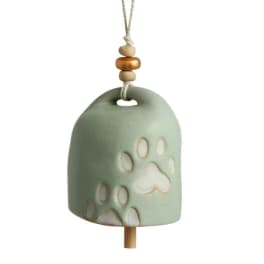 Ceramic hanging bell with paw print cutouts and a rope hanger