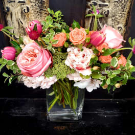 Pink and peach roses arranged in a clear glass vase