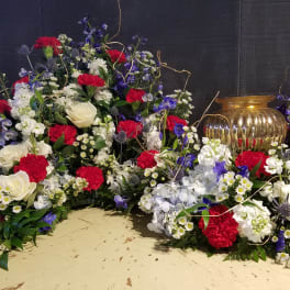 Large red, white, and blue floral arrangement with roses and carnations