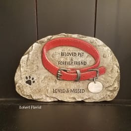 Decorative memorial stone with a red pet collar and paw print