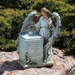 Angel statue beside a memorial pedestal with engraved text