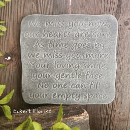 A memorial stone plaque with an engraved sympathy message.