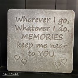 Gray memorial plaque with engraved quote and small heart balloons
