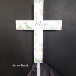 White memorial cross with floral print and the words "Mom, you are always in my heart."