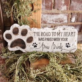 Decorative stone plaque with a paw print and memorial text