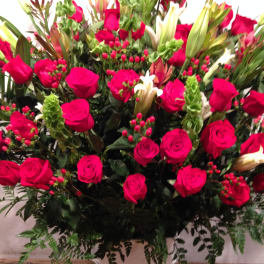 Large bouquet of hot pink roses with white lilies in a white vase