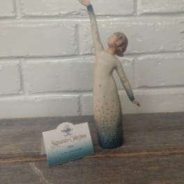 Decorative figurine of a woman in a long dress with one arm raised