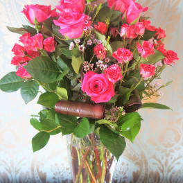 Tall bouquet of hot pink roses and spray roses in a clear glass vase