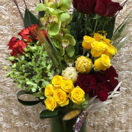 Mixed bouquet of roses and orchids in a tall green vase