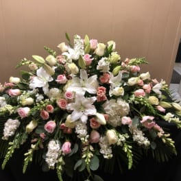 Large white and pink floral casket spray with lilies and roses