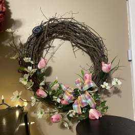 Floral wreath with pink tulips, white blossoms, and a plaid ribbon