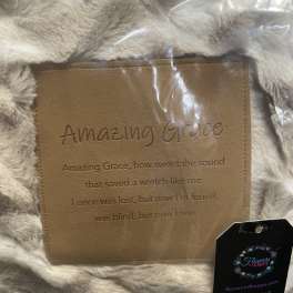 Faux fur throw with a tan embroidered panel reading Amazing Grace