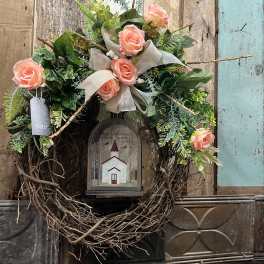Floral wreath with peach roses and a church lantern centerpiece