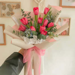 Pink tulip bouquet wrapped in cream paper with a pink ribbon