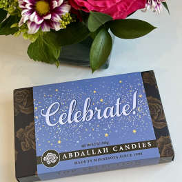 Bouquet with a pink rose and purple-white daisies beside a candy box