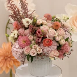 Pink and white mixed flower arrangement in a white vase