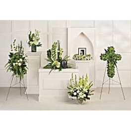White and green funeral floral arrangements on stands and pedestals