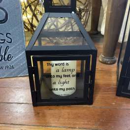 Black lantern with a candle and Bible verse text inside