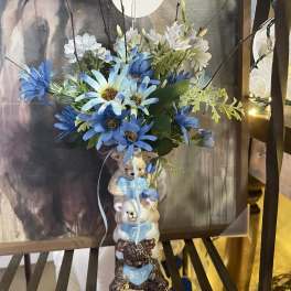 Blue and white flower arrangement in a teddy bear vase with a "boy" accent