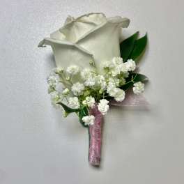 White rose boutonniere with baby's breath and pink ribbon
