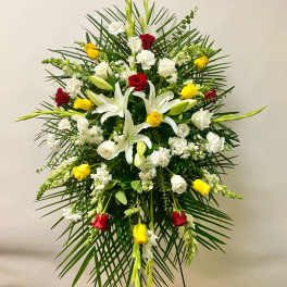 Standing floral spray with white lilies, roses, and red and yellow roses
