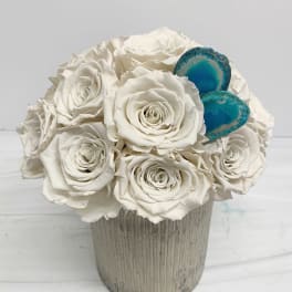 White rose arrangement in a ribbed vase with two blue agate accents