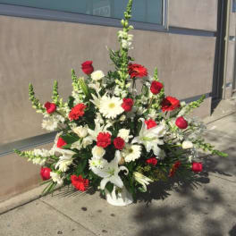 Large red and white floral arrangement in a white container