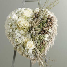 Heart-shaped white floral arrangement on an easel