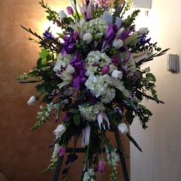 Tall purple and white floral standing spray on an easel
