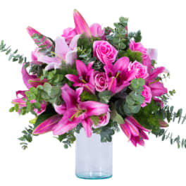 Pink lilies and roses in a clear glass vase