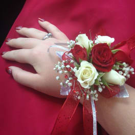 Hand corsage with red and white roses on a red dress
