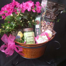 Pink flowers in a copper basket with candles and candy