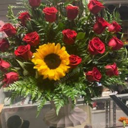 Bouquet of red roses with a yellow sunflower in a vase