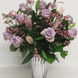 Lavender roses and pink lilies in a clear glass vase
