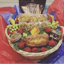 Gift basket with cookies, brownies, fruit, and packaged snacks