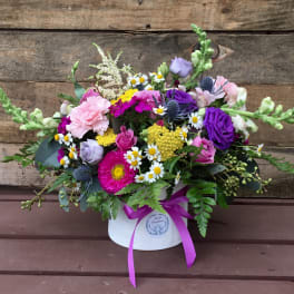 Mixed bouquet in a white hatbox with a purple ribbon