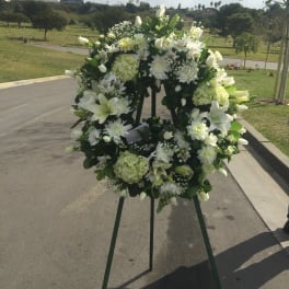 White floral wreath on a standing easel outdoors