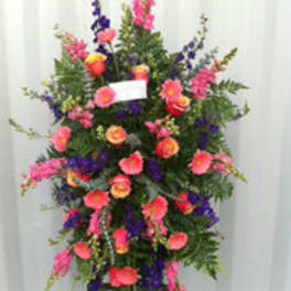 Tall standing floral spray with pink, purple, and orange blooms
