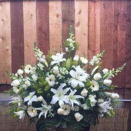 White floral arrangement with lilies and daisies in a basket
