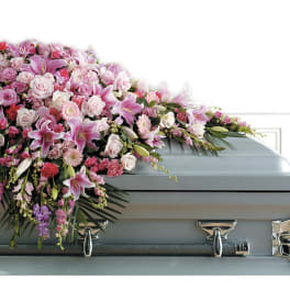 Pink and white floral casket spray with lilies and roses