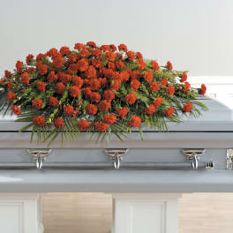 Red carnation spray on a silver casket