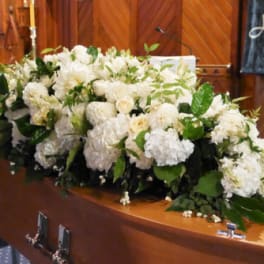 Large white floral spray on a casket
