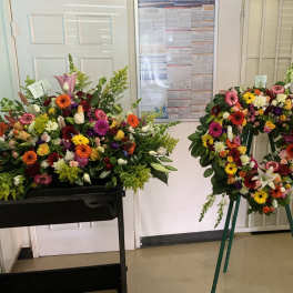 Colorful floral casket spray and standing wreath with mixed blooms