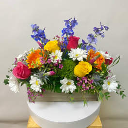Colorful mixed flower arrangement in a rectangular wooden box