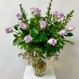Lavender roses arranged in a clear glass vase