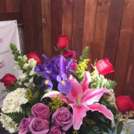 Mixed bouquet with roses, lilies, and irises in a vase