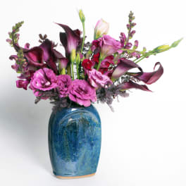 Pink and purple floral arrangement in a blue ceramic vase