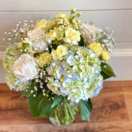 Bouquet of pale yellow and white flowers in a glass vase