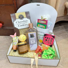 Gift box with cookies, tea, bath items, and a candle