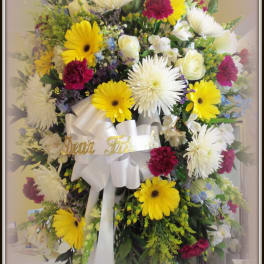 Large mixed flower standing spray with white ribbon and gold lettering